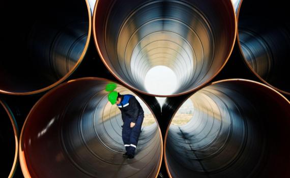 person examining metal pipes